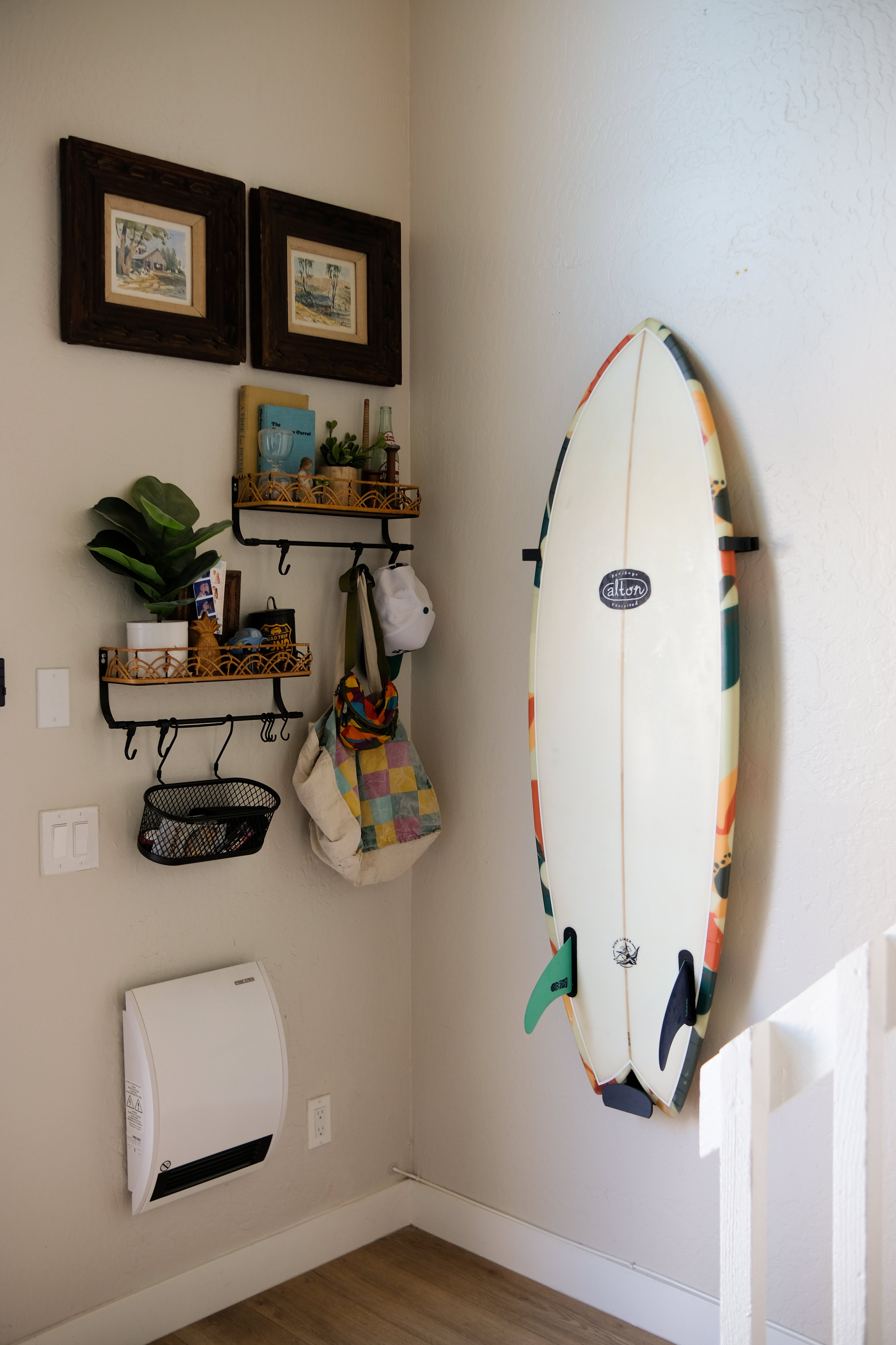 Fish surfboard mounted on an indoor wall using TrueRack surfboard mount, shown in a bright interior setting.