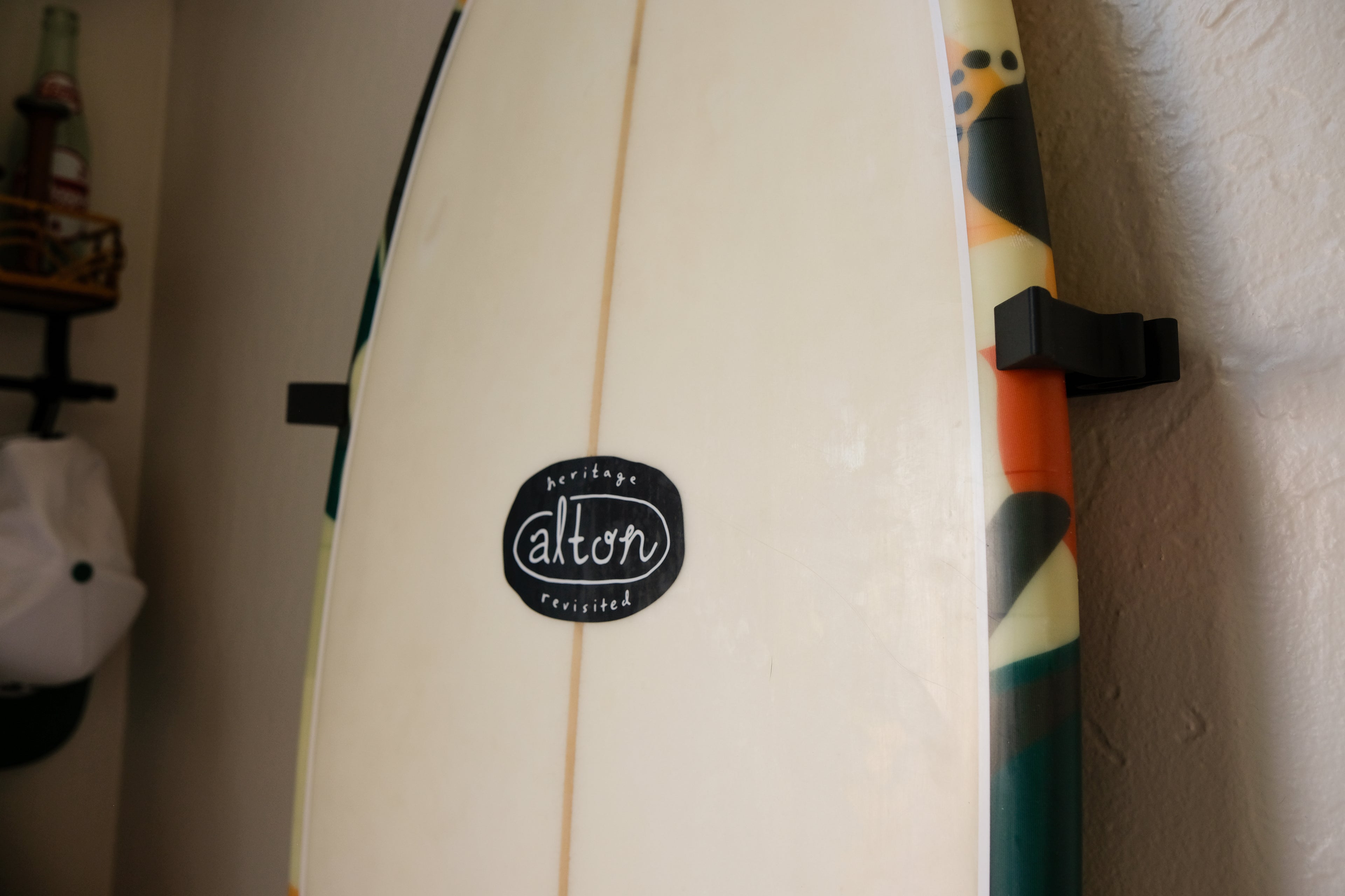 Fish surfboard mounted on an indoor wall using TrueRack surfboard mount, shown in a bright interior setting. Close up clip.